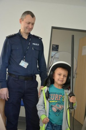policjant i chłopiec w kasku i z pałką