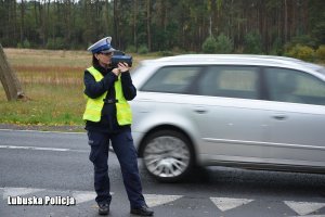 policjantka urządzeniem kontroluje prędkość z jaką jadą kierowcy