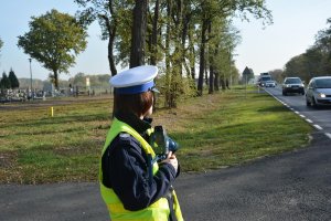 policjantka z miernikiem prędkości w rejonie cmentarza, obserwuje ruch na drodze