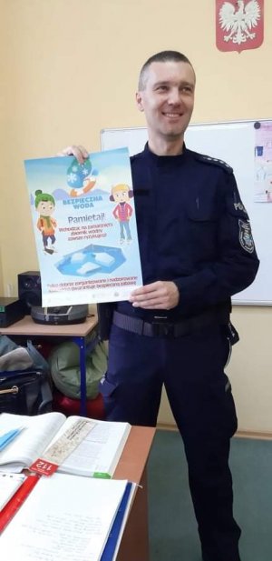 policjant pokazuje plakat