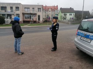 policjantka rozmawia z mężczyzną, obok fragment radiowozu