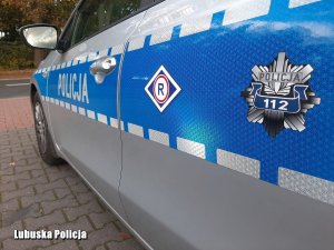 Napis policja oraz gwiazdka policyjna umieszczone na boku radiowozu