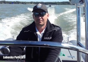 Policjant steruje łodzią