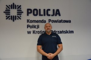 policjant na tle napisu Komenda Powiatowa Policji w Krośnie Odrzańskim