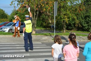 policjant kieruje ruchem podczas zajęć z dziećmi na drodze