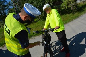 policjant kontroluje wyposażenie roweru